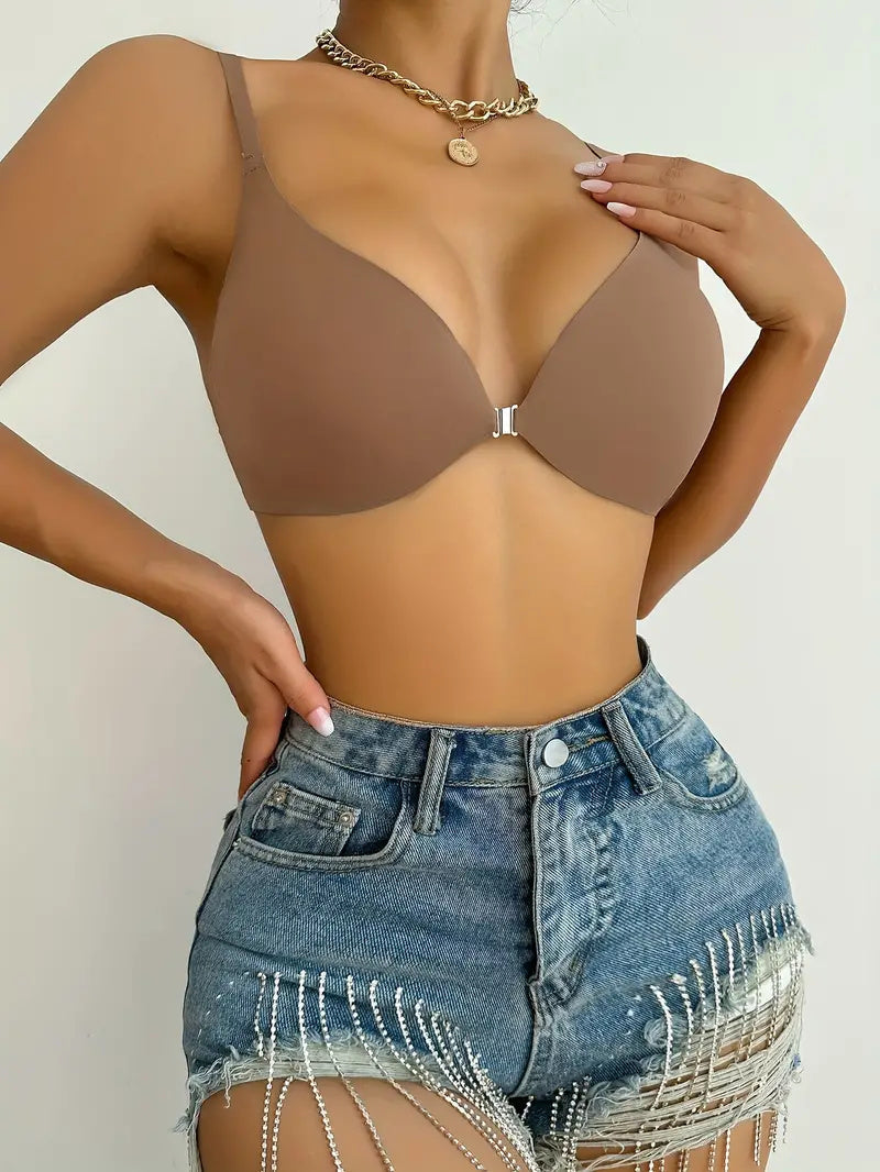Donna indossa reggiseno marrone senza cuciture e shorts di jeans con frange. Moda estiva, abbigliamento casual, stile trendy.