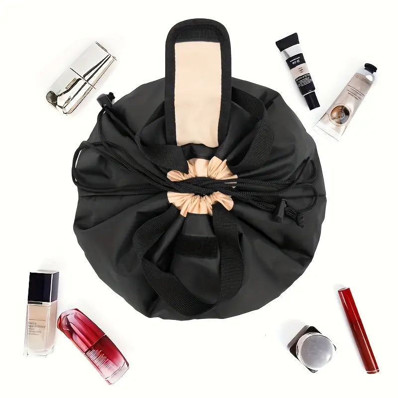 Borsa trucco nera aperta con chiusura a coulisse, circondata da cosmetici vari. Organizer da viaggio per make-up, accessori bellezza.
