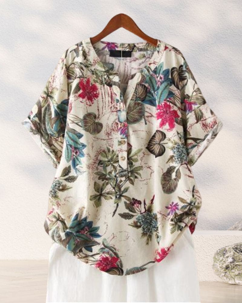 Camicia donna floreale in cotone, maniche corte, sfondo bianco, bottoni frontali, design casual estivo. Moda femminile, abbigliamento leggero.