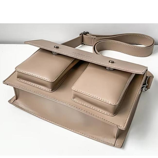 Borsa a tracolla beige in pelle con doppie tasche frontali, design elegante e moderno, ideale per moda donna. Accessorio di tendenza 2023.