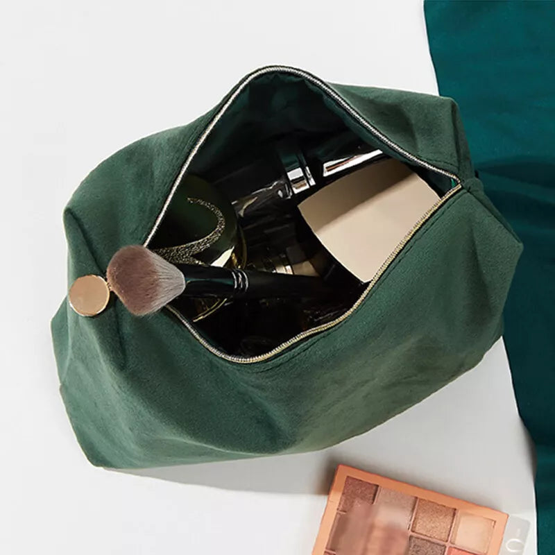 Astuccio verde per trucchi aperto, contenente pennelli e cosmetici. Accessori make-up essenziali, ideale per organizzare prodotti di bellezza.