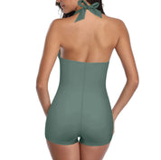 Donna in costume intero verde, schiena scoperta, con fiocco al collo. Moda mare, abbigliamento estivo, tendenza costumi 2023.