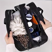 Borsa da viaggio nera aperta con prodotti cosmetici, flaconi e accessori per la cura personale. Ideale per organizzare articoli da toeletta.