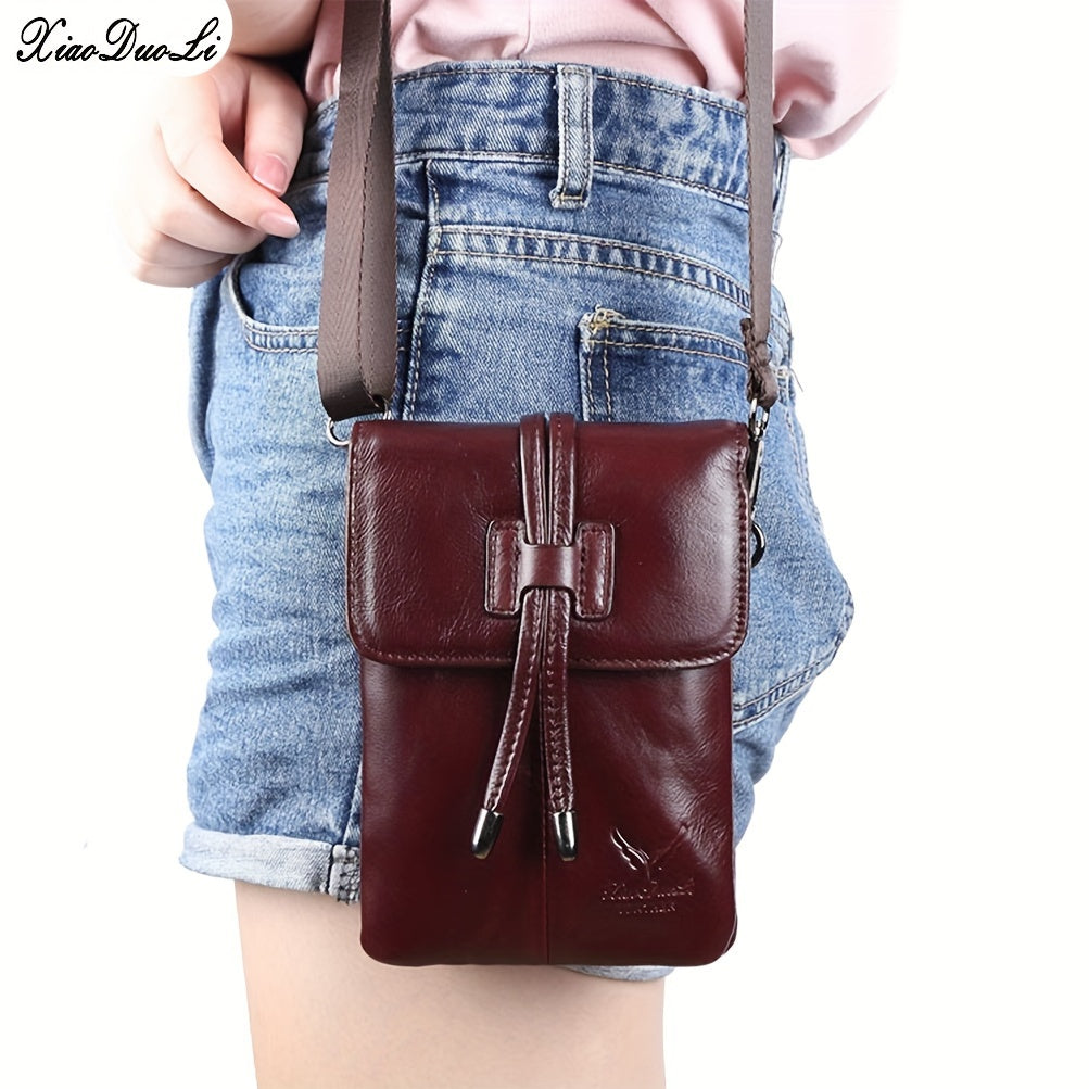 Borsa a tracolla in pelle marrone, design compatto, indossata su pantaloncini di jeans. Accessorio moda donna, stile casual ed elegante.