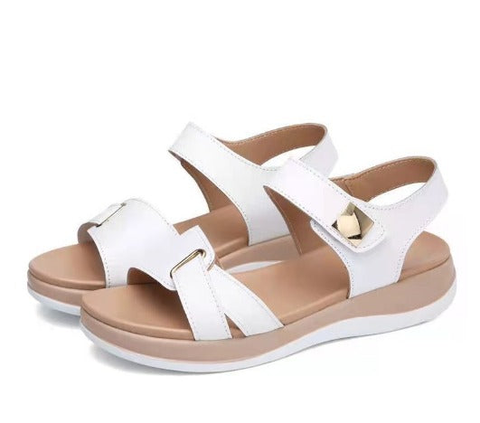 Sandali donna bianchi con cinturino regolabile, suola piatta e dettagli dorati. Calzature estive eleganti e comode per passeggiate e occasioni casual.