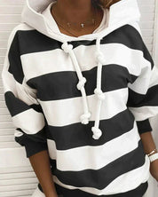 Felpa a righe bianche e nere con cappuccio e lacci, stile casual, moda donna, abbigliamento autunnale, tendenza streetwear.