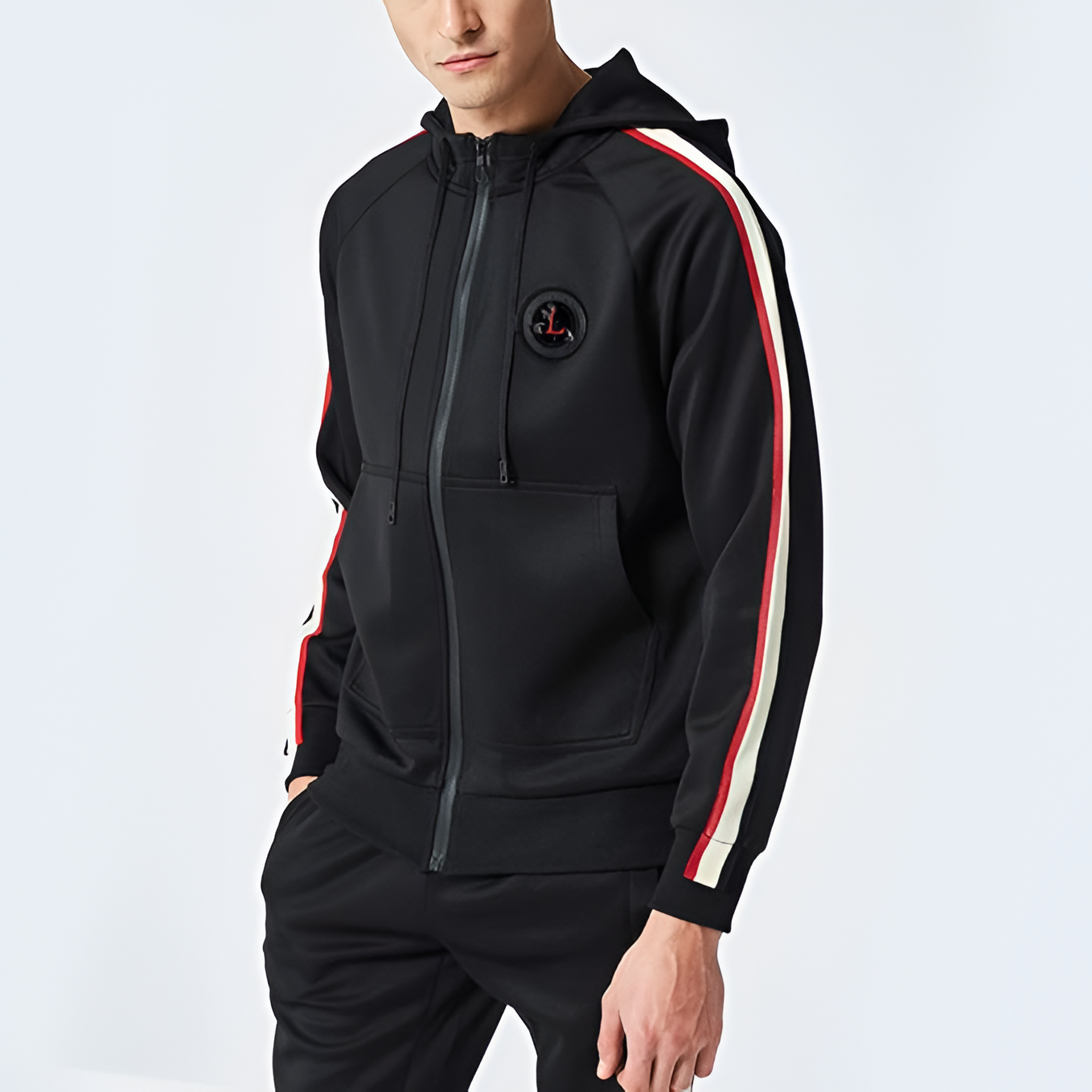 Felpa nera con cappuccio, zip frontale, dettagli a righe rosse e bianche sulle maniche, logo circolare sul petto. Moda uomo casual.