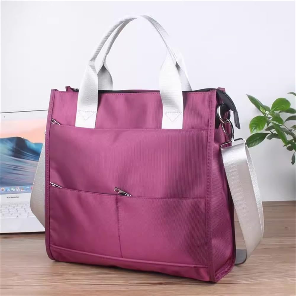 Borsa tote in nylon viola con manici bianchi e tracolla regolabile, tasche frontali con zip, su scrivania con pianta e laptop sullo sfondo.