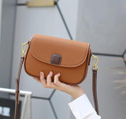 Borsa a tracolla in pelle marrone con chiusura a patta, dettagli dorati e cinturino regolabile. Elegante accessorio moda per donna.