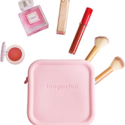 Set di cosmetici con borsa rosa, pennelli trucco, rossetto rosso, ombretto, profumo e lucidalabbra. Accessori bellezza essenziali.