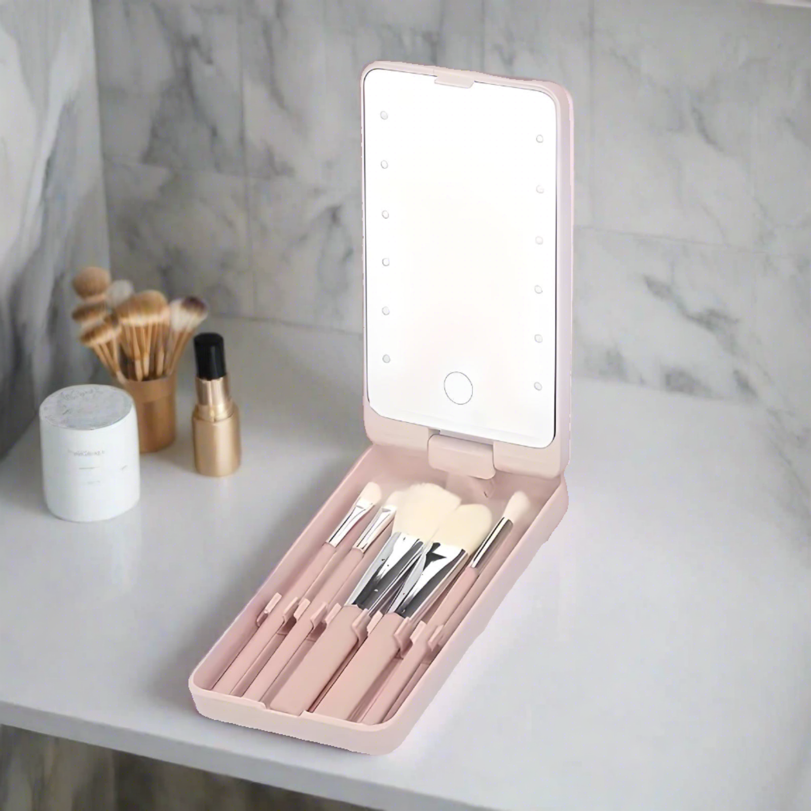 Set di pennelli trucco con specchio LED portatile su sfondo marmo. Include pennelli cosmetici di diverse dimensioni, ideale per viaggi e uso quotidiano.