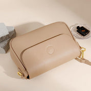 Borsa a tracolla beige in pelle, design elegante e minimalista, con chiusura a zip e dettagli dorati. Accessorio moda donna, stile casual chic.