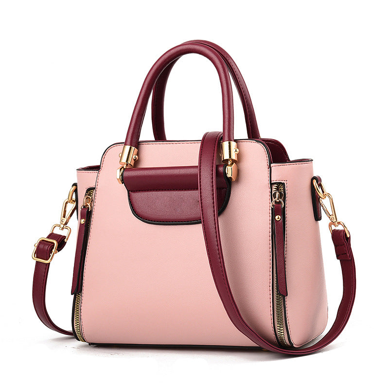 Borsa a mano elegante in pelle rosa e bordeaux con dettagli dorati, tracolla regolabile, design moderno, ideale per moda femminile.