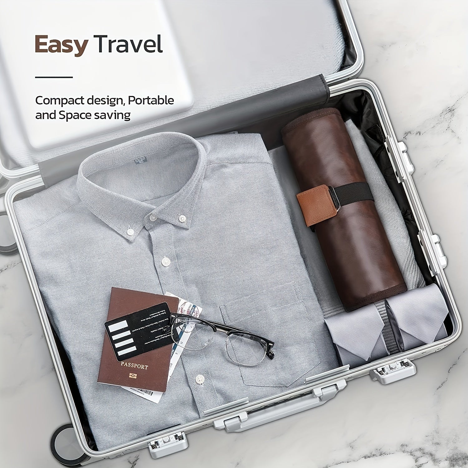 Valigia aperta con camicia grigia, custodia in pelle, passaporto e occhiali. Design compatto, ideale per viaggi facili e salvaspazio.