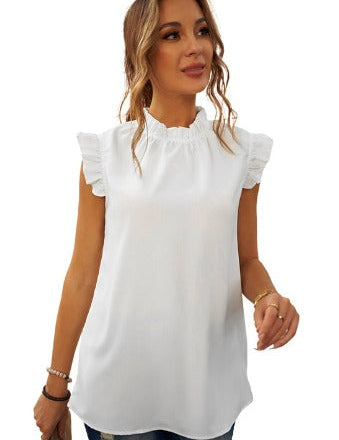Blusa bianca senza maniche con volant, scollo arricciato, indossata da donna. Moda estiva elegante, perfetta per look casual e raffinati.