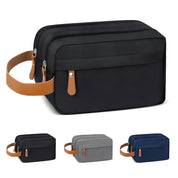 Borsa da toilette uomo in tessuto impermeabile nero con manico in pelle marrone, doppia cerniera. Disponibile in grigio, blu e nero.