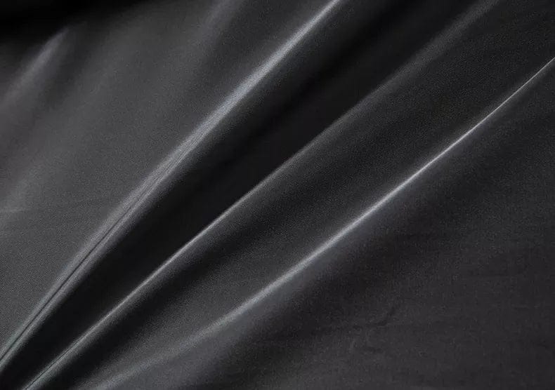 Tessuto in ecopelle nera, superficie liscia e lucida, ideale per abbigliamento e arredamento. Materiale resistente e di alta qualità.