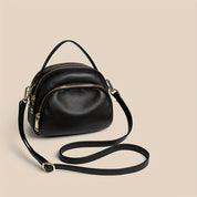 Elegante borsa a tracolla in pelle nera con doppia zip e dettagli dorati, perfetta per moda donna e accessori di lusso.