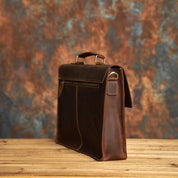 Elegante borsa ventiquattrore in pelle marrone su sfondo rustico, ideale per lavoro e ufficio. Design classico, alta qualità artigianale.