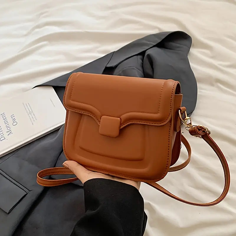 Borsa a tracolla in pelle marrone su sfondo nero, design elegante e moderno, perfetta per moda donna, accessorio versatile e chic.