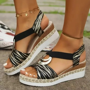 Sandali estivi con zeppa, motivo zebrato, cinturino alla caviglia, suola in corda intrecciata, dettagli metallici, moda donna, calzature eleganti.