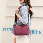 Borsa a tracolla donna in tessuto rosso, indossata su camicia di jeans. Design casual, ideale per moda quotidiana. Accessorio femminile trendy.