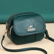 Borsa a tracolla verde in pelle sintetica con logo dorato, chiusura a zip, e tracolla regolabile. Elegante accessorio moda donna.
