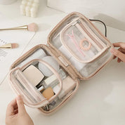 Astuccio da trucco trasparente aperto, contenente pennelli, spugne e accessori cosmetici. Ideale per organizzare il make-up in viaggio.