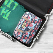 Valigia aperta con borsa organizer a fantasia elefanti e maglietta verde. Accessori viaggio, organizzazione bagagli, valigia cabina.