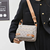 Borsa a tracolla donna in tessuto beige con motivo geometrico, dettagli in pelle marrone, chiusura zip, ideale per moda casual e shopping.
