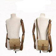 Borsa a tracolla in tela beige su manichino, design vintage, chiusura a fibbia, ideale per uomo e donna, moda casual, accessorio unisex.