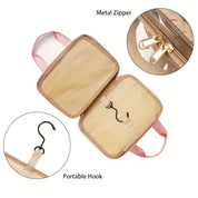 Borsa da viaggio beige con cerniera in metallo e gancio portatile, ideale per organizzare cosmetici e accessori. Design compatto e funzionale.