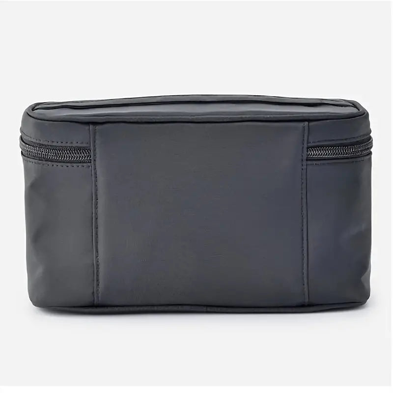 Astuccio da viaggio nero in pelle sintetica con cerniera, design compatto e moderno, ideale per organizzare accessori e cosmetici.