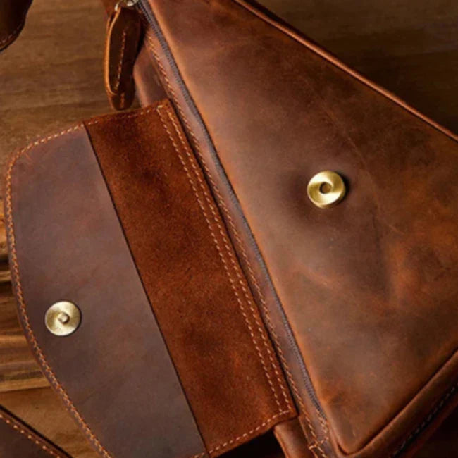Borsa a tracolla in pelle marrone vintage, chiusura a bottone dorato, design elegante e resistente, ideale per uomo e donna, accessorio moda.