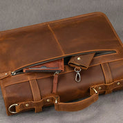 Borsa ventiquattrore in pelle marrone con cerniere e manico robusto, ideale per lavoro e viaggi. Design elegante e funzionale.