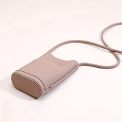 Borsa a tracolla in pelle rosa chiaro, design minimalista, ideale per smartphone. Accessorio moda elegante e pratico per ogni occasione.
