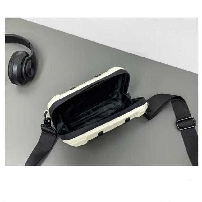 Borsa a tracolla bianca aperta su tavolo grigio, con cuffie nere accanto. Design moderno, ideale per accessori moda e tecnologia.