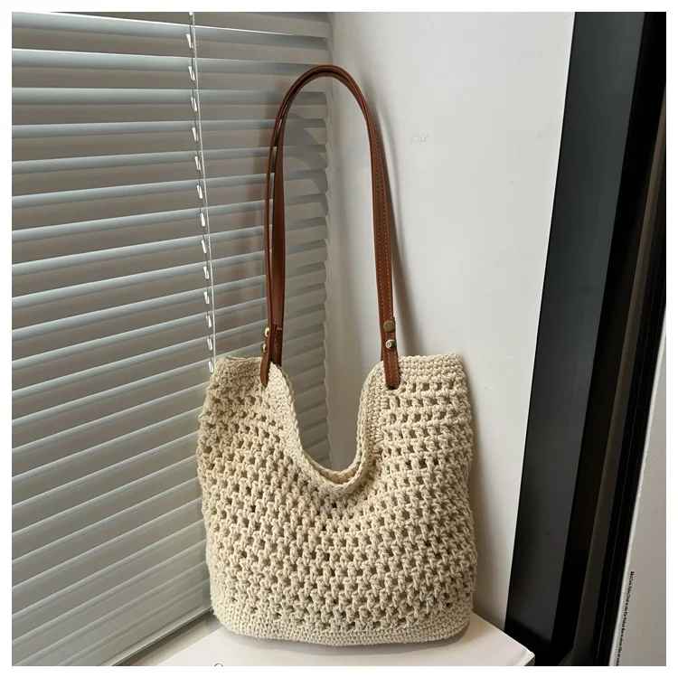 Borsa a spalla in maglia beige con manici in pelle marrone, design elegante e moderno, perfetta per moda donna, accessorio casual chic.