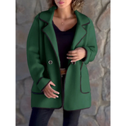 Giacca verde donna, elegante e casual, con bottoni e tasche, indossata su top nero e jeans. Moda autunnale, stile moderno.