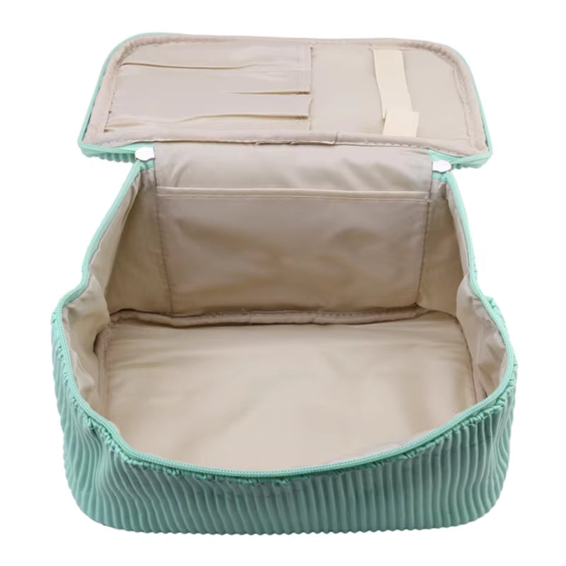 Borsa organizer da viaggio verde menta aperta, con scomparti interni, ideale per valigia, accessori, cosmetici. Design pieghevole e compatto.