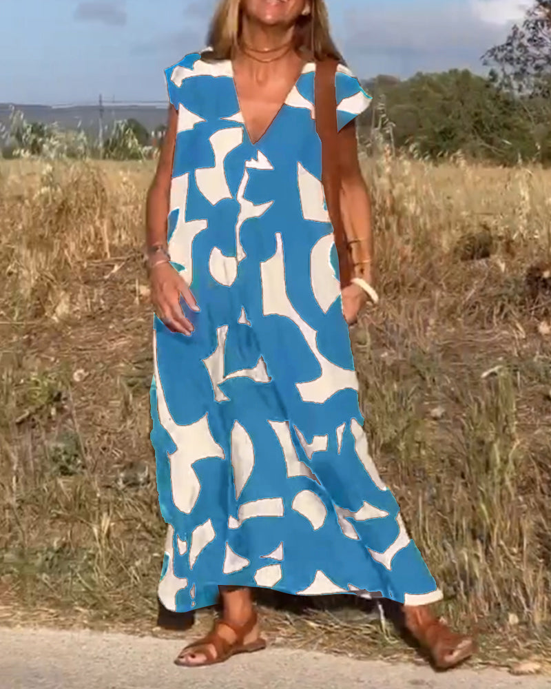 Donna con abito lungo estivo blu e bianco, motivo astratto, in piedi su strada di campagna. Sandali marroni, sfondo naturale. Moda casual estiva.