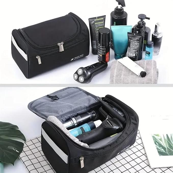 Borsa da toilette nera con zip, contenente prodotti per la cura personale e rasoio elettrico, su sfondo bianco. Accessori da viaggio uomo.