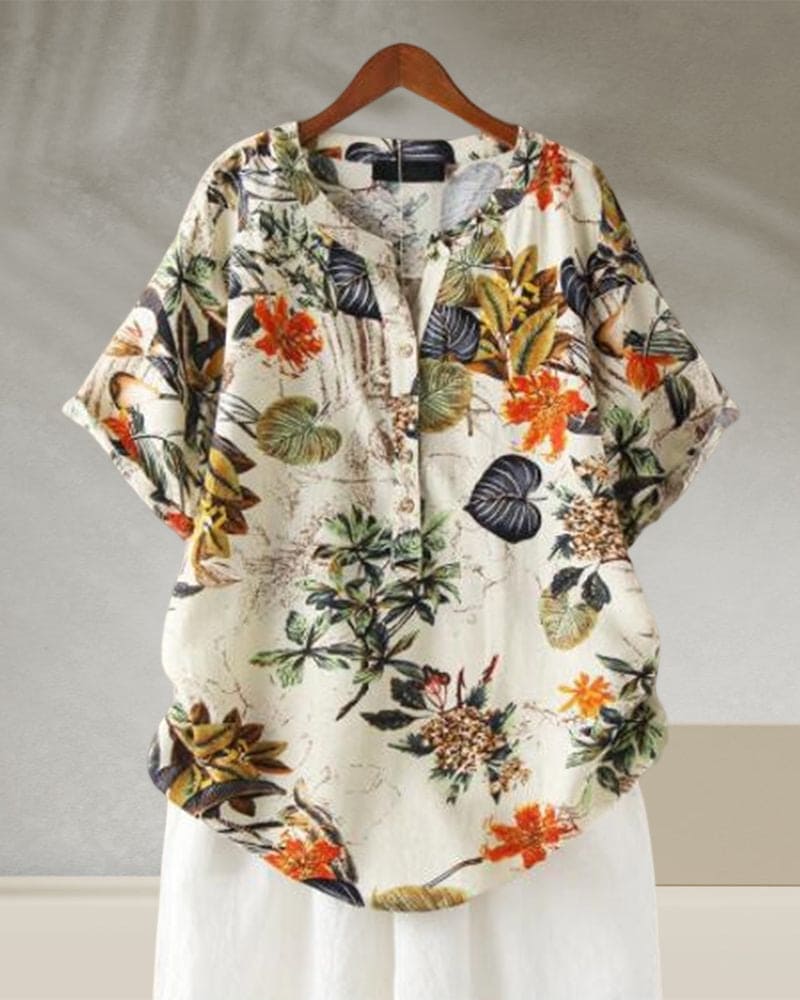 Camicia donna floreale, maniche corte, bottoni, sfondo bianco, stampa tropicale colorata. Moda estiva casual, tessuto leggero e traspirante.