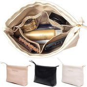 Borsa da trucco beige aperta con scomparti, contenente cosmetici e accessori. Disponibile in tre colori: beige, nero e rosa. Organizzatore viaggio.