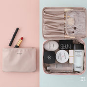 Borsa trucco beige con rossetto rosso, eyeliner e set di cosmetici di lusso, tra cui Chanel e Dior, su sfondo rosa. Organizzazione beauty travel.