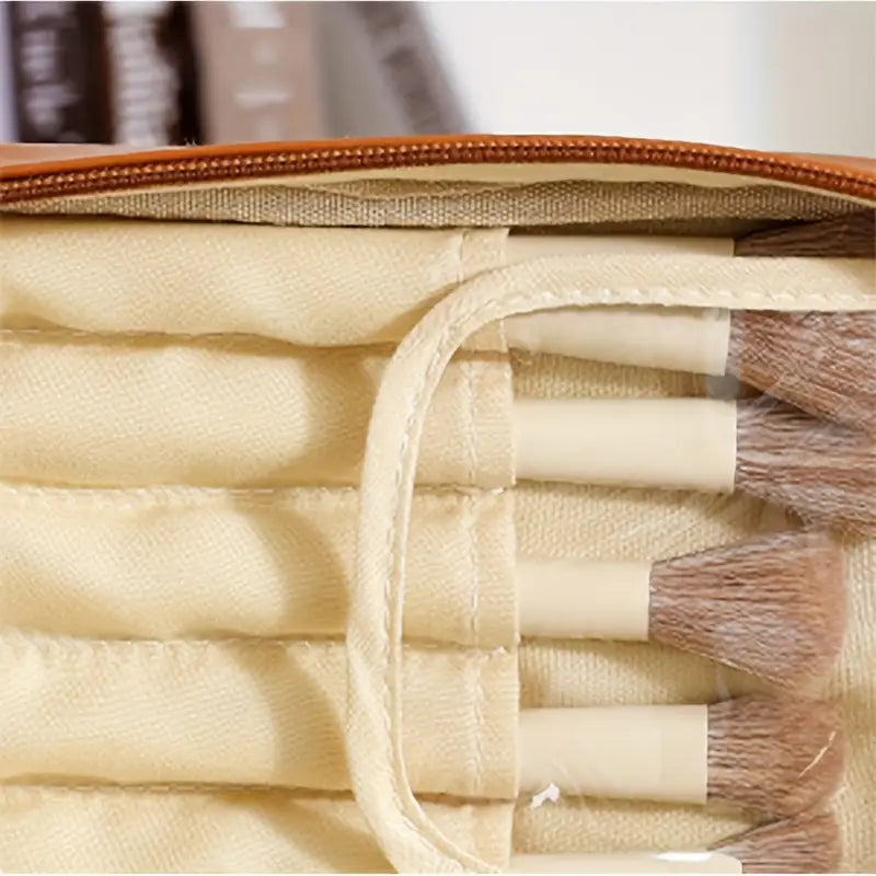 Set di pennelli trucco in custodia beige, setole morbide, manici chiari. Ideale per applicazione cosmetici, accessorio essenziale per make-up artist.