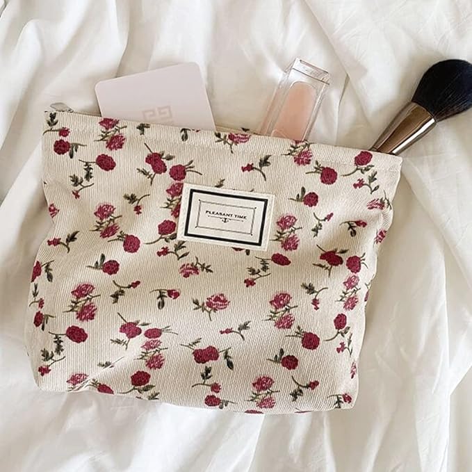 Pochette trucco floreale con rosse rose, contenente pennello, lucidalabbra e carta. Accessorio moda donna, elegante e pratico per cosmetici.