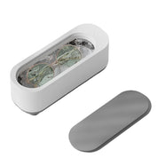 Dispositivo pulizia occhiali ad ultrasuoni bianco, coperchio grigio, design moderno, ideale per lenti e gioielli. Accessorio casa essenziale.