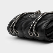 Borsa a tracolla in pelle nera trapuntata con catena metallica argentata, design elegante e moderno, accessorio moda donna di lusso.