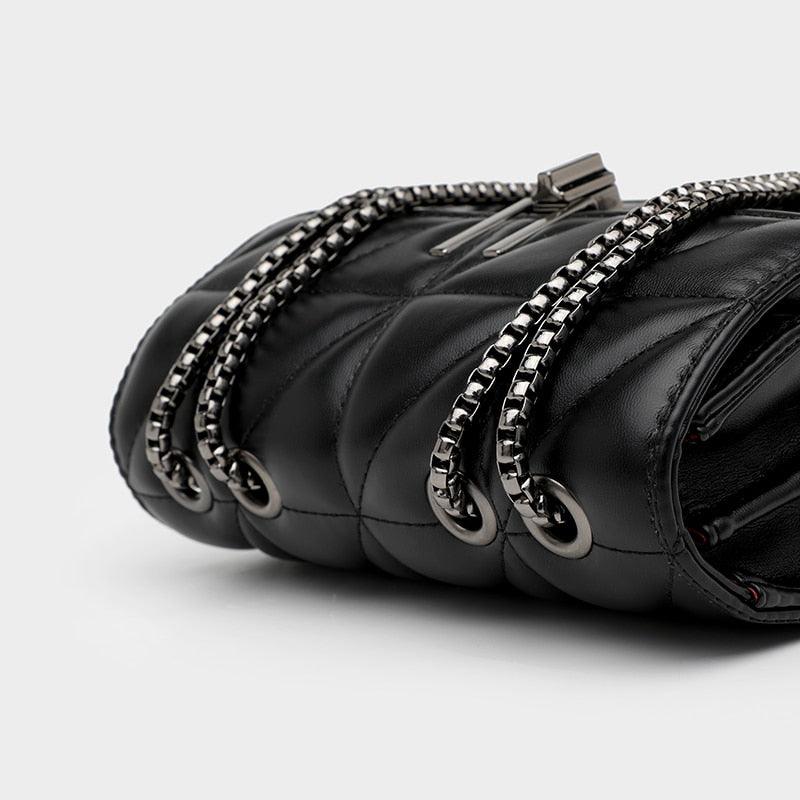 Borsa a tracolla in pelle nera trapuntata con catena metallica argentata, design elegante e moderno, accessorio moda donna di lusso.